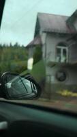 View in the side rear view mirror of a car driving a red car on a highway video