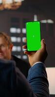 Vertical Diverse staff reviews documents in a wooden library at CIA safe house, using green screen tech and blending intelligence analysis. Briefing each other on critical mission details. Camera A. video