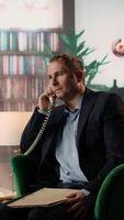 Vertical Intelligence officer on a secure line answering phone call in CIA safe house, gathering field information from undercover informants scattered around the city. Sensitive details. Camera A. video