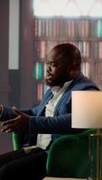 Vertical Businessmen in a classy library discuss partnership goals over whiskey, reflecting trust, success and the luxury of elite social circles. Upper class society members meeting at the club. Camera B. video