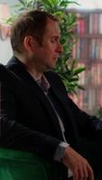Vertical Two multiethnic businessmen sharing a whiskey glass in an elegant library, discussing business strategy and building trust. Confident gentlemen embodying luxury and elite social culture. Camera B. video