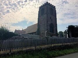 A large church with a clock tower and a fence photo