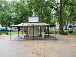 A gazebo in a park with trees and benches photo
