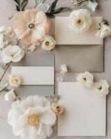 Creative flat lay composition with delicate pink and white flowers arranged around blank card, invitation, space for text photo