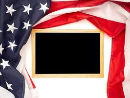 Top view of the American flag and empty mini blackboard on a white background photo