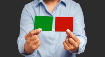 Hands businessman holding red and green color paper while standing on a gray background photo