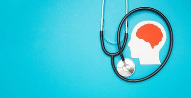 A brain shape made from paper and a stethoscope on a light blue background photo