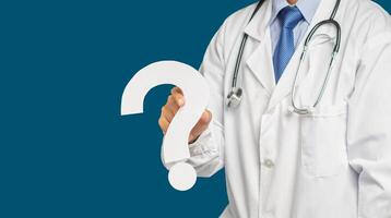 Midsection of a doctor in uniform holding a white question mark while standing on a blue background photo