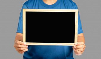 Close-up of hands holding a blank mini blackboard while standing on a gray background photo