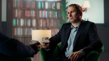 Gallant investor consultant engage in a meaningful conversation with a friend, enjoying a fine scotch and making propositions for a new business opportunity at the elite social club. Camera B. video