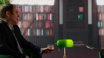 Diverse men in a secret service library reviewing classified reports over whiskey, focusing on evidence for an undercover mission. CIA intelligence duo reviewing documents in a stylish HQ. Camera A. video