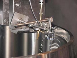 Close-up of precision industrial machinery with metal components, wires, and a sensor. Ideal for engineering, tech, or abstract backgrounds. photo