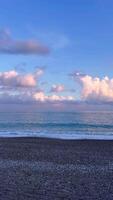 Beautiful evening at the beach with gentle waves and colorful clouds video