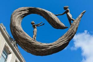 A sculpture depicting two figures reaching out, symbolizing connection and unity. photo