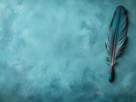 A decorative feather quill rests on a textured turquoise background, evoking creativity. photo