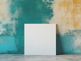A blank canvas against a textured teal and yellow wall, inviting creativity and expression. photo