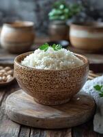 A bowl of fluffy rice garnished with herbs, set on a wooden surface. photo
