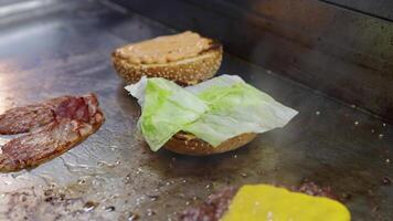 Cook preparing a burger with bacon video
