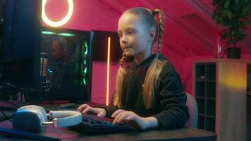 Little girl teenage daughter child kid playing computer game online gaming addicted play net web driving car in neon light room indoors modern cyber automobile simulation generation addiction video