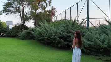 Girl Walking in a Green Garden Surrounded by Lush Plants on a Sunny Summer Day video