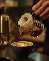 A person pours coffee into a cup photo