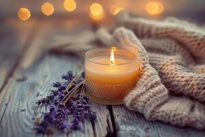 Close-Up of Lit Candle on Rustic Wooden Table with Lavender and Knitted Fabric photo