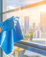 A person in blue gloves cleaning a window photo