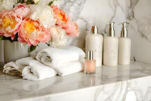 A marble counter with a vase of flowers and towels photo