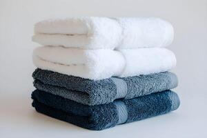 A stack of four towels on a white surface photo