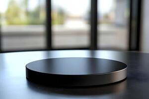 A black circular object on a table in front of a large window photo
