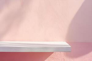 A white shelf against a pink wall photo