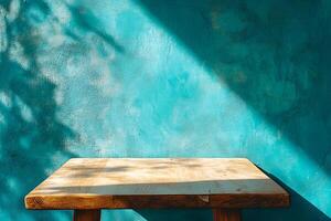 A wooden table sitting against a blue wall photo