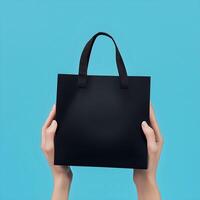 Hands holding a black shopping bag on a blue background photo