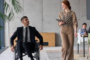 Director in a Wheelchair Engaging in a Business Discussion with a Colleague While Navigating a Modern Office photo