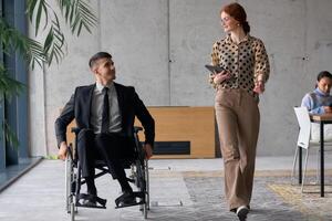 Director in a Wheelchair Engaging in a Business Discussion with a Colleague While Navigating a Modern Office photo