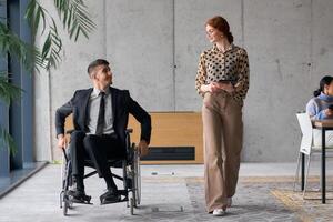 Director in a Wheelchair Engaging in a Business Discussion with a Colleague While Navigating a Modern Office photo