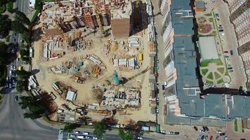 Top aerial view of a construction site in the city. View from above on roofs of newly built high-rise flats next to the construction works. Urban background. video