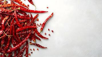 A pile of red chili peppers on a white surface photo