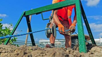 Engineering works. Technician works with building equipment outdoors. Construction area on the ground. video