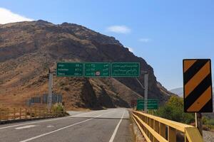 Ardabil Province, Iran - September 30, 2024 A road sign provides important information about distances to nearby cities in a mountainous area of Iran, guiding travelers along the route photo