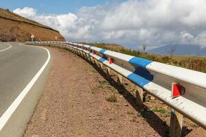 Scenic highway with guardrail winding through the mountains of Armenia on a clear day photo