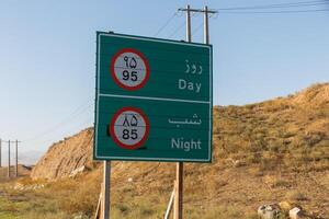 Speed limit sign indicating restrictions for day and night driving in Iran's rural area photo