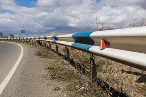 Scenic roadside view in Armenia with guardrails and distant mountain backdrop photo
