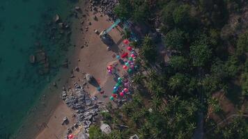 Aerial View of Phuket Beach with Umbrellas, Rocks, and Greenery video