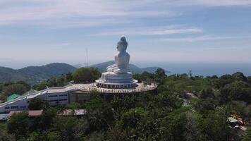 Antenne Aussicht von das groß Buddha Statue auf nackt hügel, umgeben durch Grün mit das Andaman Meer und Phukets Küste im das Hintergrund. video