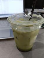 Closeup of a cup of matcha latte on the desk photo