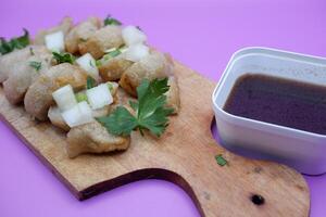 pempek isolated on purple background. typical food from sumatera, indonesia. typical food made from fish and flour. photo