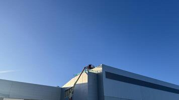Partial View of Light Gray Building Under Construction with Aerial Lift photo