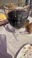 Dark Red Wine in Stemmed Glass with Food on Table photo