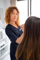 Female dermatologist examining anonymous client's skin in beauty salon photo